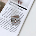 transparent TPU watchband for Apple Watch resting on a magazine page featuring a silver buckle design.