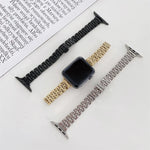 Three steel replacement straps for Apple Watch, showcasing black, gold, and silver options next to a watch face.
